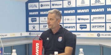 Igrači Širokog Brijega i Posušja bore se za loptu na natopljenom terenu stadiona Pecara, dok jaka kiša pada tijekom utakmice.